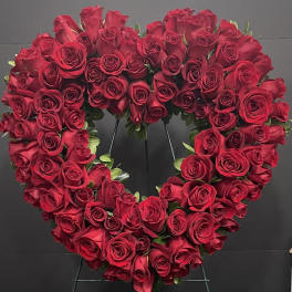 Heart-shaped wreath of red roses on a stand