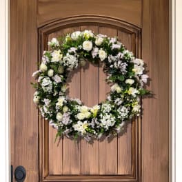 White floral wreath on a wooden door
