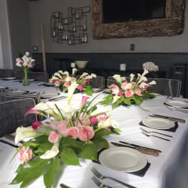 Pink and white floral centerpieces on a set dining table