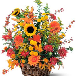 Basket arrangement with sunflowers, orange lilies, and mixed fall flowers