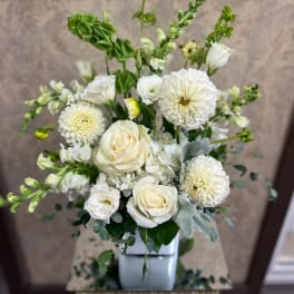 White roses and round white blooms in a square vase