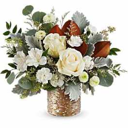 White roses and small white flowers in a woven basket vase
