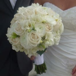 Bride holding a white bouquet of roses and ranunculus