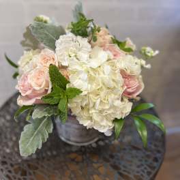 Bouquet of pale pink roses and white hydrangeas in a metal vase