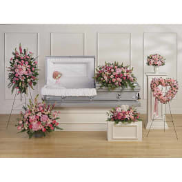 Pink floral funeral casket spray with matching wreaths and arrangements