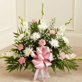 Pink and white floral arrangement with a large pink bow