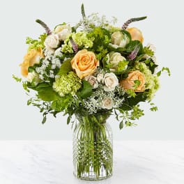 Bouquet of peach and white roses in a clear glass vase