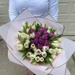 Bouquet of white and purple tulips wrapped in pale pink paper