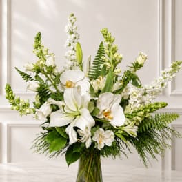 White orchids and lilies arranged in a clear glass vase