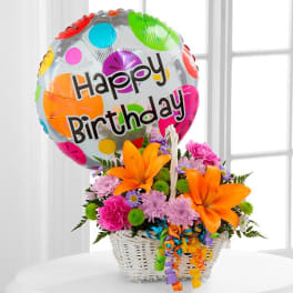 Birthday balloon above a colorful flower basket