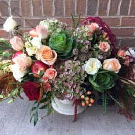 Mixed bouquet with roses, hydrangeas, and apples in a white vase