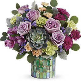 Compact bouquet of purple and green flowers with a succulent in a mosaic cylinder vase