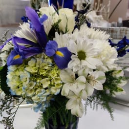 Blue and white mixed bouquet in a tall cobalt vase