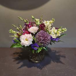 Mixed bouquet in a glass vase with purple, white, and pink flowers