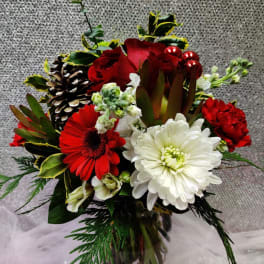 Red and white mixed flower arrangement in a glass vase