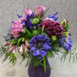Purple and pink mixed bouquet in a purple vase