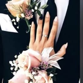Two floral wrist corsages with pale pink roses and white accents