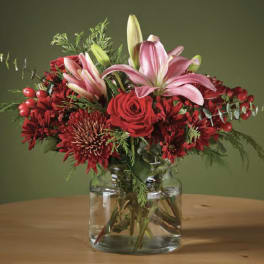 Red and pink floral arrangement in a clear glass vase