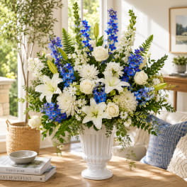 White and blue floral arrangement in a white vase