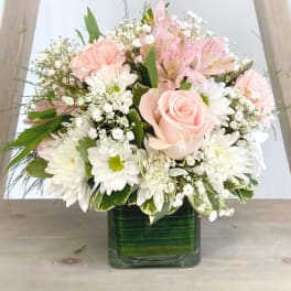 Pink and white mixed bouquet in a square glass vase