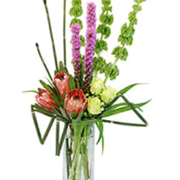 Tall bouquet of pink and green flowers in a clear glass vase