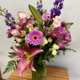 Mixed bouquet of pink and purple flowers in a glass vase