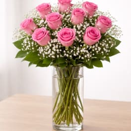 Pink roses arranged in a clear glass vase with white filler flowers
