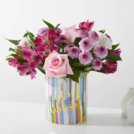 Pink and purple bouquet in a striped "Let's Celebrate" container