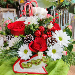 Red roses and white daisies arranged in a decorative sleigh container