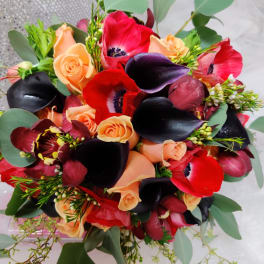 Bouquet of red and peach flowers with dark calla lilies