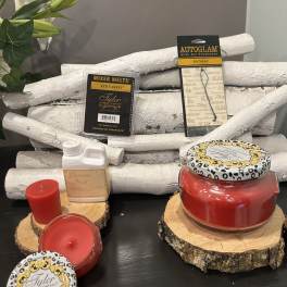 Assorted red candles and fragrance products on wood slices