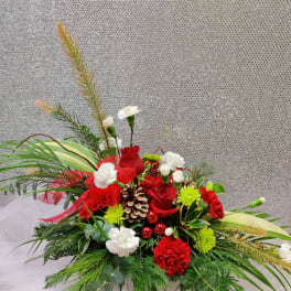 Red and white floral arrangement with pinecones and greenery