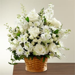 White roses and daisies arranged in a woven basket