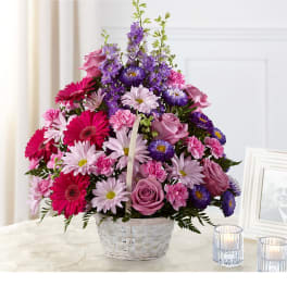 Basket arrangement of pink, purple, and white flowers
