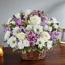 Basket arrangement of white roses, daisies, and purple flowers