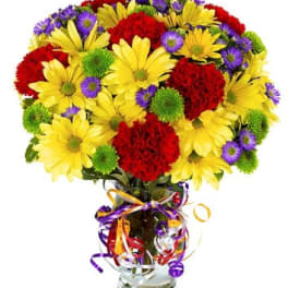 Bouquet of yellow daisies, red carnations, and purple asters in a glass vase