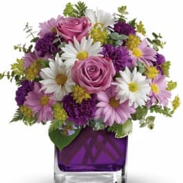 Pink roses and white daisies in a purple glass vase