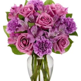 Pink and purple bouquet of roses and carnations in a glass vase