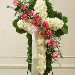 Standing floral spray with white blooms and pink roses on a white easel