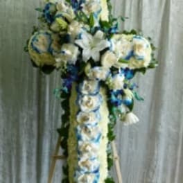 White floral cross on an easel with blue accents
