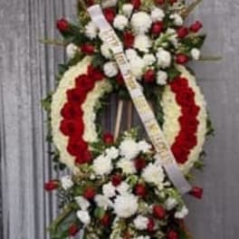 Standing funeral wreath with red and white flowers on an easel