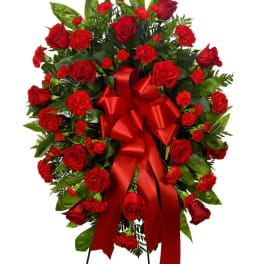 Red rose and carnation standing spray with a red ribbon bow
