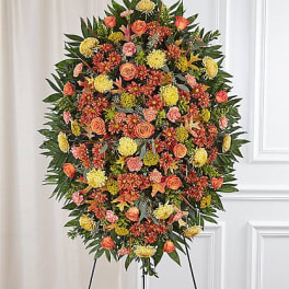 Large standing floral spray with orange, yellow, and pink blooms