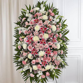Standing funeral spray with pink and white flowers on an easel