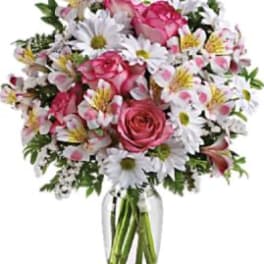 Pink roses and white daisies in a clear glass vase