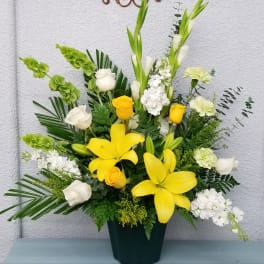 Yellow lilies and white roses in a dark vase
