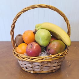 Basket of assorted fruit including bananas, apples, pears, oranges, and kiwi