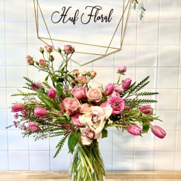 Pink bouquet with roses and tulips in a glass vase