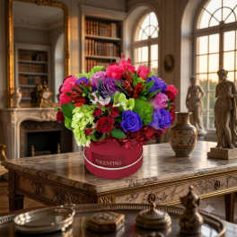 Bright mixed bouquet in a pink round box on a marble table