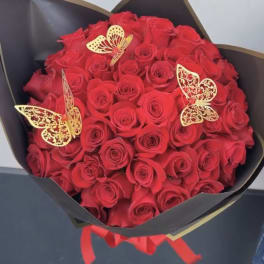Bouquet of red roses wrapped in black paper with gold butterfly accents